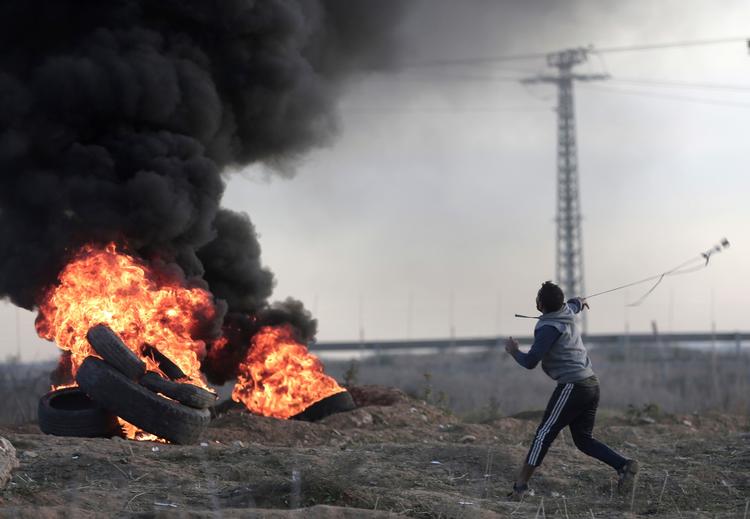 Palæstinensiske demonstranter kaster sten på grænsen mellem Israel og Gaza i mandags.  