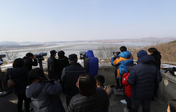 Sydkoreanere ser i kikkert over grænsen til Nordkorea første nytårsdag i år. 