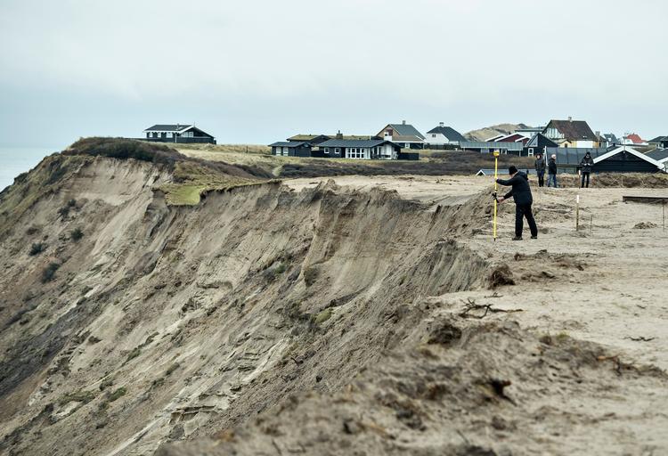 En medarbejder fra Kystdirektoratet med landmålerudstyr fotograferet ved sommerhusområdet i Lønstrup for en uge siden.  