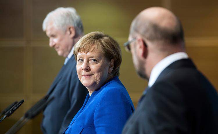 Horst Seehofer, længst til venstre, i et muntert øjeblik med Angela Merkel og den daværende formand for socialdemokraterne, Martin Schulz, da den nye regerings planer blev offentliggjort. I går benyttede han igen lejligheden til at lange ud efter Merkels flygtningepolitik. Bernd von Jutrczenka/AP
