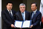 Præsidenten for Nordkoreas olympiske komité og tillige sportsminister Kim Il Guk (tv.), præsidenten for Den Internationale Olympiske Komité, Thomas Bach, og Sydkoreas sportsminister Do Jong-hwan præsenterer erklæringen, der sender 22 nordkoreanske atleter til vinter-OL. 