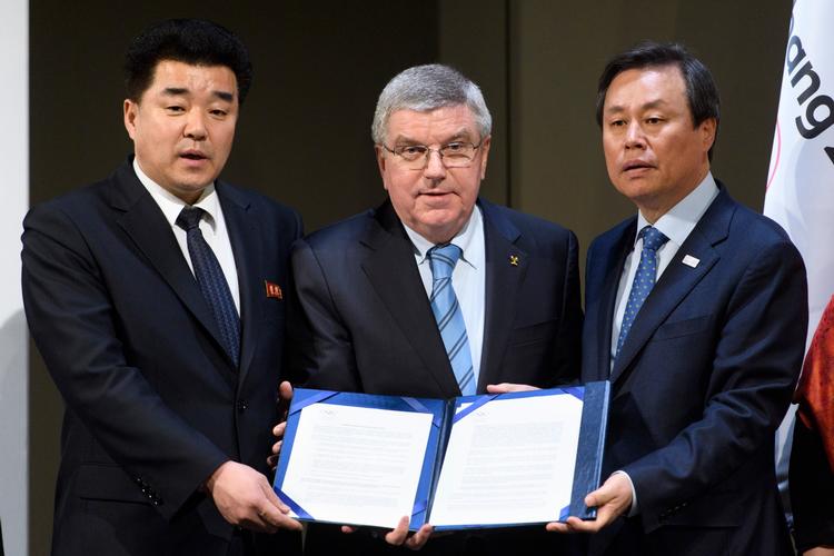 Præsidenten for Nordkoreas olympiske komité og tillige sportsminister Kim Il Guk (tv.), præsidenten for Den Internationale Olympiske Komité, Thomas Bach, og Sydkoreas sportsminister Do Jong-hwan præsenterer erklæringen, der sender 22 nordkoreanske atleter til vinter-OL. 