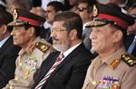 Sami Anan (th.), politiker og tidligere forsvarsminister Hussein Tantawi (tv.) og tidligere præsident
Mohammed Morsi (midten) deltager i en ceremoni på en militærbase øst for Egyptens hovedstad Cairo. 