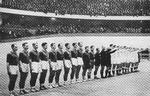 Et - som det vist hedder - ikonisk håndboldbillede fra det første VM i 1938. Danmark møder de senere verdensmestre fra Det Tredje Rige i Deutschlandhalle i Berlin. Danskerne står til venstre, de heilende tyskere til højre. Der var 12.000 tilskuere omkring 6-dagesbanen. Tyskerne vandt 12-3.
   
