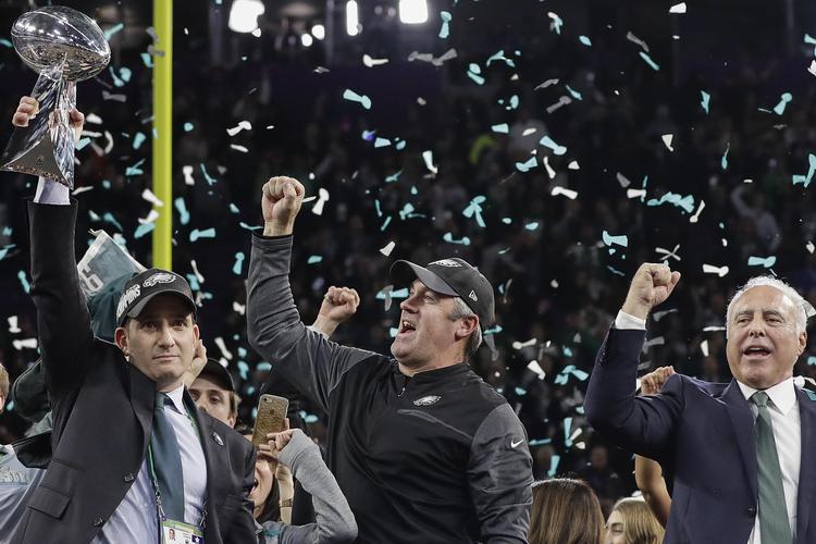 Philadelphia Eagles manager Howie Roseman (til venstre) holder sejrspokalen på. Ved siden af ham står  træner Doug Pederson og holdejer Jeffrey Lurie. 