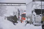 Japanske soldater går langs de mange køretøjer, der er strandet på motorvejen Route 8 mellem byerne Sakai og Awara.
   