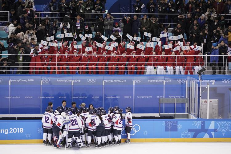 Nordkoreanske tilskuere hylder det fælles koreanske hold efter kampen mod Schweiz, der blev tabt 0-8.
   
