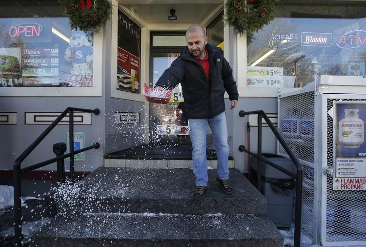Sam Safa ejer Reeds Ferry Market i Merrimack i New Hampshire, hvor vinderkuponen blev købt. Her spreder han salt på sin isglatte trappe. 