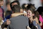 Medlemmer til en af eleverne på den skole i Florida, hvor det senete skyderi foregik i går, forsøger at trøste hinanden. 