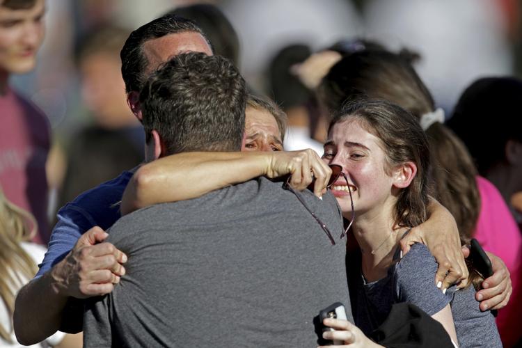 Medlemmer til en af eleverne på den skole i Florida, hvor det senete skyderi foregik i går, forsøger at trøste hinanden. 
