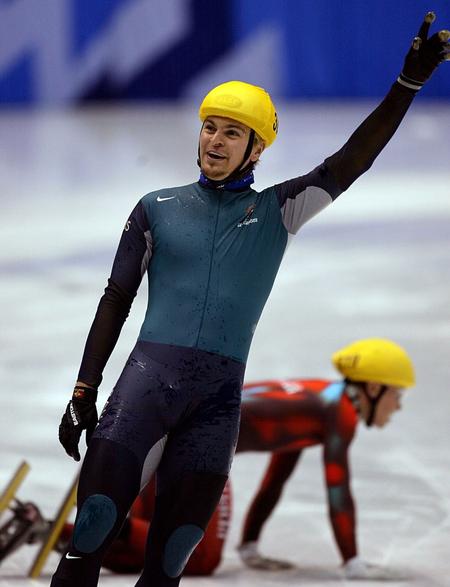 Steven Bradbury vinder sensationelt guldmens blandt andet Canadas Mathieu Turcotte kravler rundt på isen i baggrunden.
   