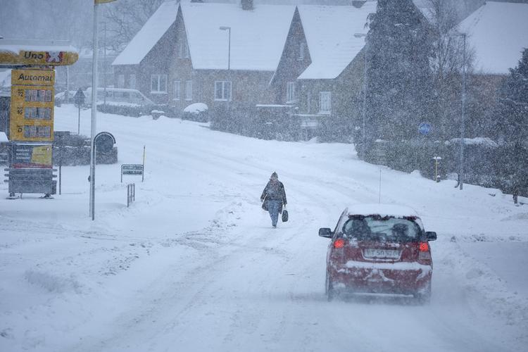 Sne og vintervejr på Bornholm. Her en ældre kvinde på vej til bussen i Klemensker i går.
   Pelle Rink/Ritzau Scanpix