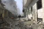 En mand løber af sted gennem et sønderskudt område i det østlige Ghouta. Billedet er offentliggjort af aktivistiske regeringsmodstandere fra Ghouta Media Center. 
   Uncredited/AP