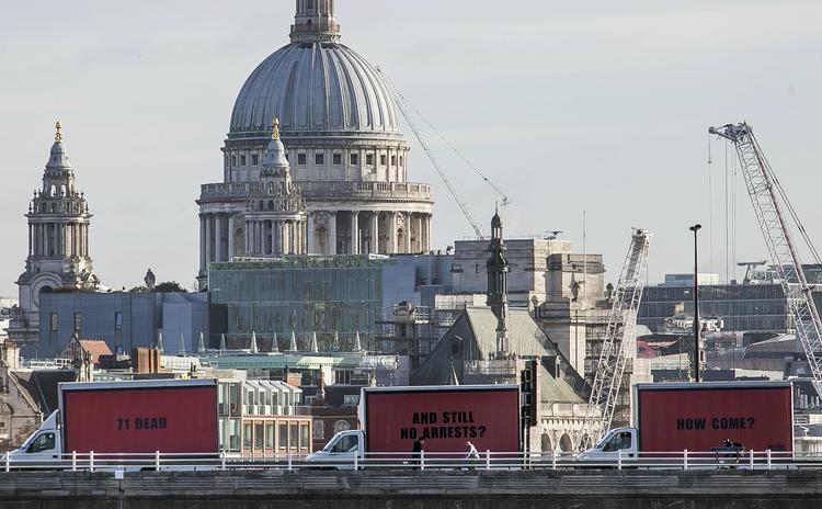Organisationen Justice4Grenfell står bag de tre kørende billboards - her med det ikoniske St. Pauls Cathedral i baggrunden.  Jeff Moore/AP