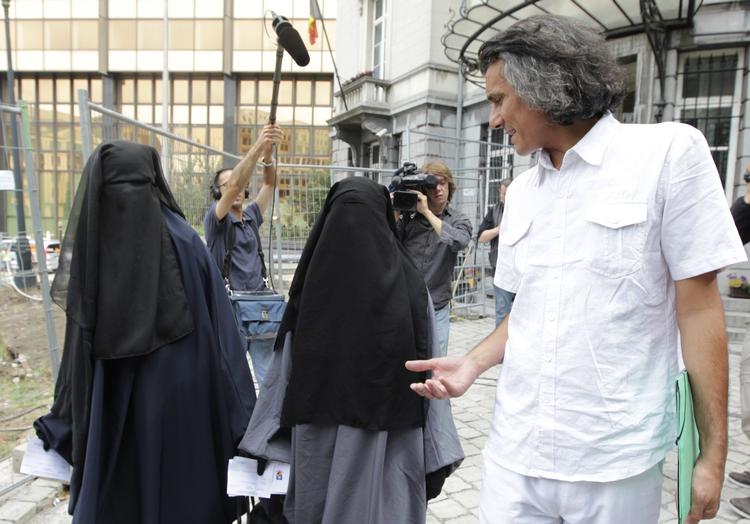 Rachid Nekkaz (manden til højre) taler med to kvinder, som hver er blevet idømt en bøde på 50 euro, fordi de har tildækket sig i Bruxelles. Arkivfoto Yves Logghe