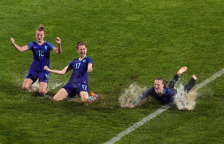 Algarve Cup druknede i regn, så hollænderne  Esmee De Graaf (tv.), Merel Van Dongen (i  idten) og Sheila Van Der Bulk (th.) tog sig en glidetur i vandet i stedet for at spille finale. Francisco Leong/Ritzau Scanpix