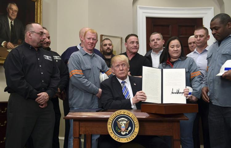 Arbejdere fra stålindustrien var med, da Donald Trump i det ovale værelse underskrev beslutningen om at pålægge straftold på importeret stål og aluminium. Susan Walsh/AP