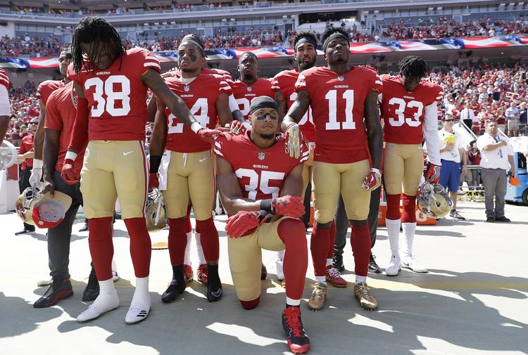 Eric Reid (knælende) var den første mand til at tilslutte sig Colin Kaepernicks protest. Spørgsmålet er nu, om det kan koste ham karrieren, ligesom det skete for Kaepernick. Foto: AP
   Marcio Jose Sanchez/AP