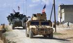 Amerikanske styrker er allerede i Syrien. Her en amerikansk patrulje i byen Manbij. Nu truer USA også med et missilangreb. Arkivfoto.
     Uncredited/AP