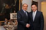 Den kinesiske forretningsmand Li Yonghong besegler sit køb af AC Milan ved at trykke den hidtidige ejer, Silvio Berslusconi, i hånden.  Livio Anticoli/AP