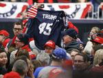 Trump-tilhængere vifter med en trøje med hans navn under et rally tidligere i år.  Keith Srakocic/AP