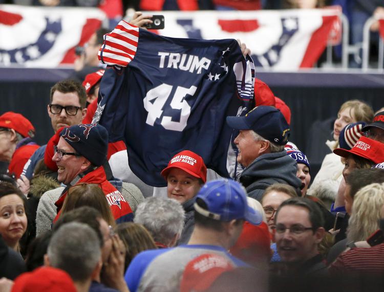Trump-tilhængere vifter med en trøje med hans navn under et rally tidligere i år.  Keith Srakocic/AP