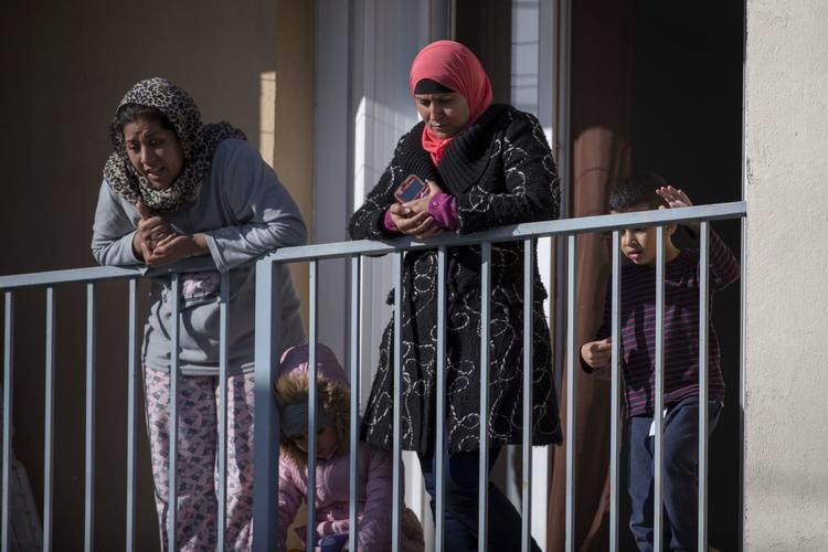 Indbyggere i Trebes ser til, mens betjente og redningsarbejdere arbejder på gerningsstedet.  Emilio Morenatti/AP