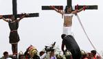 Til højre på billedet hænger Ruben Enaje, som lader sig korsfæste for 32. gang for at opleve Jesus Kristus pinsler.
   Aaron Favila/AP