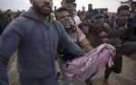 Protesterende palæstinensere bærer en såret mand, der er ramt af israelske soldater.  Khalil Hamra/AP