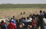 Unge palæstinensere er samlet nær græsen til Israel.  Khalil Hamra/AP