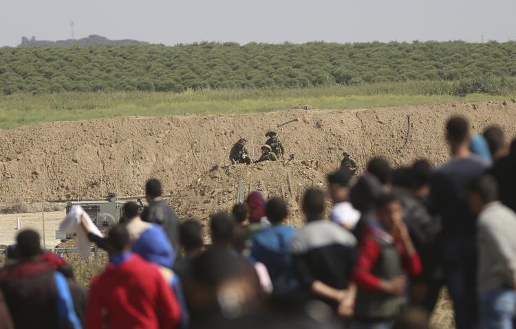 Unge palæstinensere er samlet nær græsen til Israel.  Khalil Hamra/AP