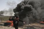 En palæstinenser slynger sten mod israelske soldater. 
   Khalil Hamra/Ritzau Scanpix