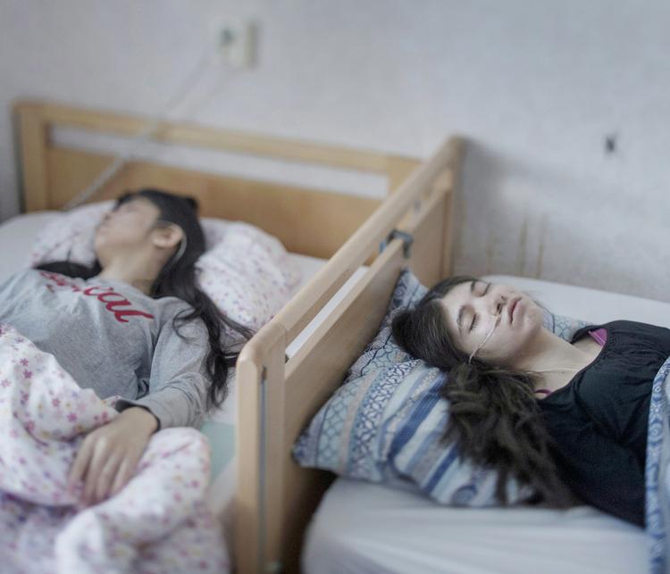 Djeneta (til højre) har været sengeliggende og fuldstændig apatisk i to et halvt år, og hendes søster Ibadeta i seks måneder, i Horndal i Sverige. De har 'uppgivenhetssyndrom' (modløshedssyndrom), en lidelse, som kun menes at eksistere blandt flygtninge i Sverige. Foto: Magnus Wennman, Aftonbladet 