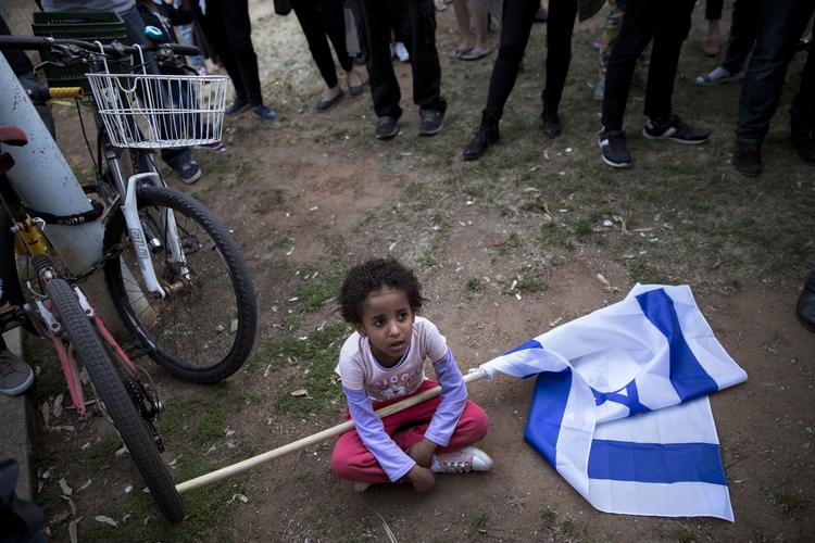 Et afrikansk migrantbarn fotograferet i mandags under en demonstration mod deportation af afrikanske migranter fra Israel.  Oded Balilty/AP