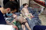 Redningsfolk fra de »Hvide Hjelme« hjælper børn efter angrebet med klorgas på en bygning i Douma uden for Syriens hovedstad 7. april.
   /AP
