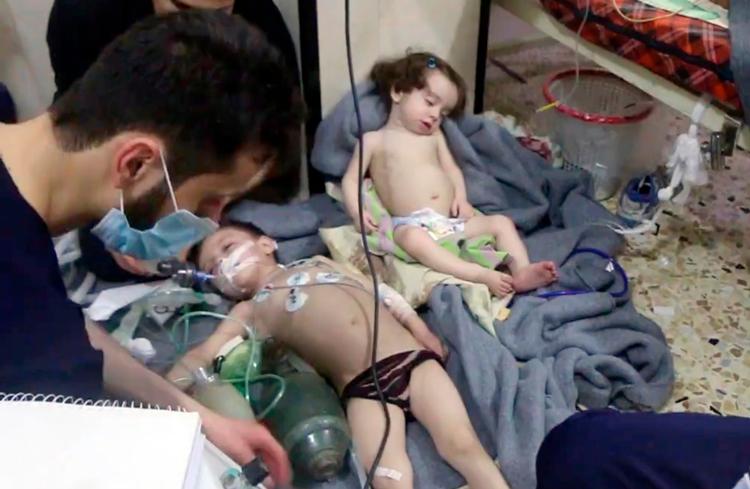 Redningsfolk fra de »Hvide Hjelme« hjælper børn efter angrebet med klorgas på en bygning i Douma uden for Syriens hovedstad 7. april.
   /AP