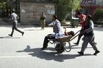 En såret mand køres væk efter bombeangrebet i Kabul.  Rahmat Gul/AP