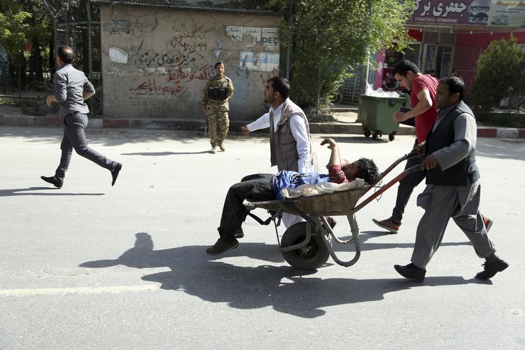 En såret mand køres væk efter bombeangrebet i Kabul.  Rahmat Gul/AP