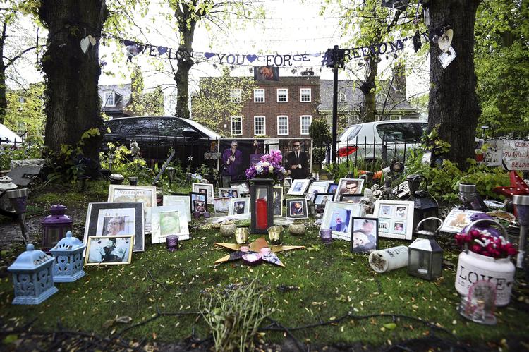 
George Michaels fans har nærmest etableret en mindepark på et stykke jord overfor  den afdøde sangers hus  i Highgate i det nordlige London. Hans familie beder nu stjernens fans fjerne blomster, billeder og andre hilsner foran sangerens to hjem af hensyn til naboerne. (Kirsty O'Connor/PA via AP)
   Kirsty O'connor/AP