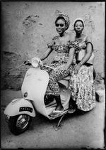 Med lånte solbriller og tasker, sætter to kvinder fra Bamako sig op på en Vespa Scooter. Untitled, 1957 © Seydou Keïta /SKPEAC / courtesy CAAC - The Pigozzi Collection, Geneva
