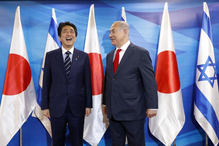 Shinzo Abe (tv) ser ikke ud til at være tynget for meget af det afskoelige måltid med Benjamin Netanyahu. Abir Sultan/AP