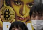 Bitcoin er en virtuel valuta men ikke mere virtuel, end at der også bliver reklameret for den i store, fysiske reklamer som denne på Shibuya togstationen i Tokyo i februar.  Shizuo Kambayashi/AP