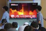 Lokale i Seoul går forbi en tv-skærm med billeder fra en nordkoreansk missiltest i 2017. Nu blæser der tilsyneladende mildere vinde, og Nordkorea nedtager angiveligt sit prøveområde for atomvåben. 
  Ahn Young-joon/AP