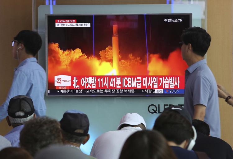 Lokale i Seoul går forbi en tv-skærm med billeder fra en nordkoreansk missiltest i 2017. Nu blæser der tilsyneladende mildere vinde, og Nordkorea nedtager angiveligt sit prøveområde for atomvåben. 
  Ahn Young-joon/AP