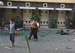 Politibetjente går forbi 
Santa Maria-kirken i Surabaya, der søndag morgen ligesom to andre kirker blev ramt af et terrorangreb.   Trisnadi/AP