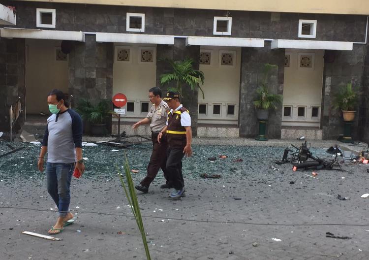 Politibetjente går forbi 
Santa Maria-kirken i Surabaya, der søndag morgen ligesom to andre kirker blev ramt af et terrorangreb.   Trisnadi/AP