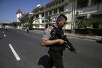 En betjent holder vagt foran politiets hovedkvarter i Indonesiens næststørste by Surabaya. Hovedkvarteret blev mandag morgen udsat for et angreb kun dagen efter, at tre kirker også blev angrebet i byen.
 Achmad Ibrahim/AP