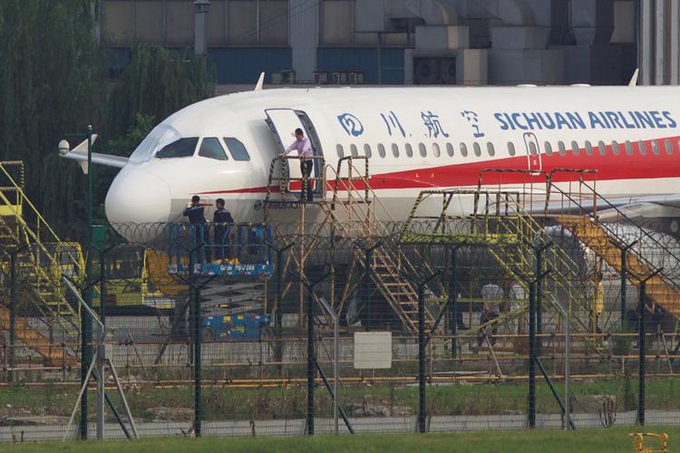 Maskinen fra Sichuan Airlines, der mandag morgen oplevede et uheld med et af flyets vinduer, bliver undersøgt i lufthavnen i Chengdu. China Stringer Network/Ritzau Scanpix