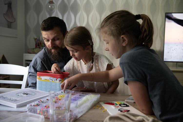 René Godballe Nöstler hygger med døtrene Astrid (6) og Vega (10) inden aftensmad. Han hjælper dem gerne med at finde perler til perlepladerne i de rigtige farver.
   
   Peter Hove Olesen/POLFOTO