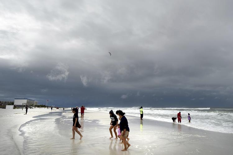 Strandgæster på Okaloosa Island i Fort Walton Beach, Florida mandag. Den subtropiske storm 'Alberto' blev ikke helt så kraftig som ventet. Alligevel var der flere dødsfald.  Nick Tomecek/AP